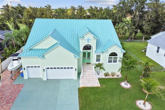 view of front of home featuring a garage, a front yard, and french doors