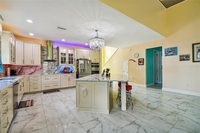 kitchen featuring backsplash, wall chimney range hood, a center island, hanging light fixtures, and stainless steel appliances