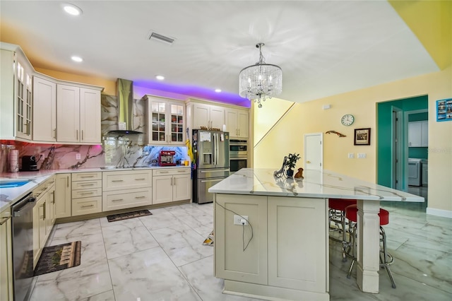 kitchen featuring appliances with stainless steel finishes, tasteful backsplash, hanging light fixtures, wall chimney exhaust hood, and a center island