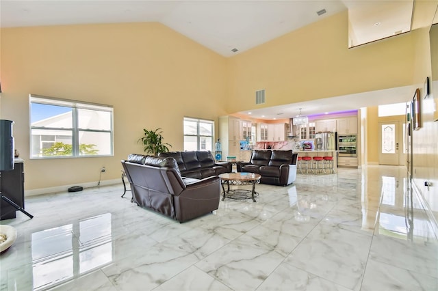 living room with high vaulted ceiling and an inviting chandelier