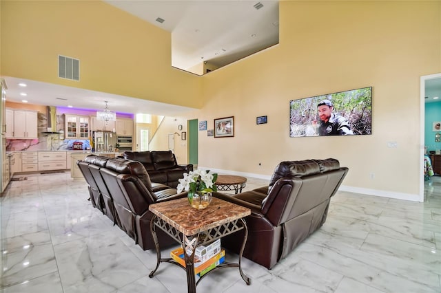 living room with an inviting chandelier and a high ceiling