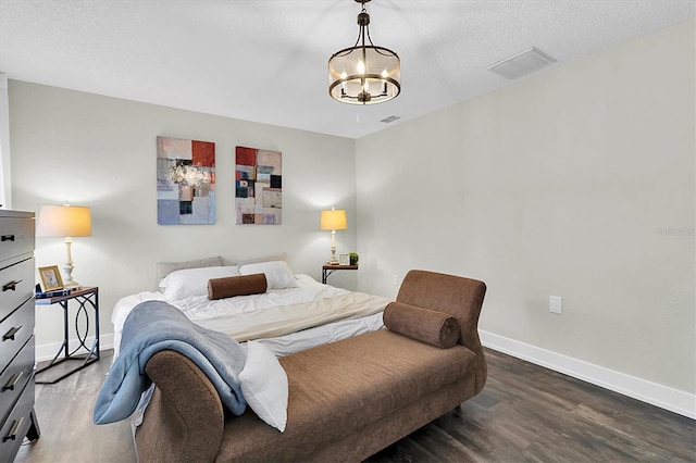 bedroom with a chandelier and dark hardwood / wood-style floors