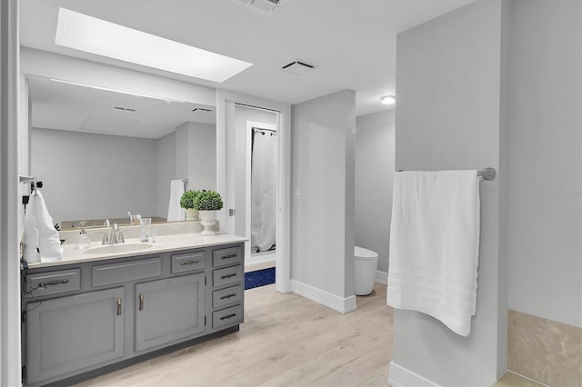 bathroom with wood-type flooring, toilet, and vanity