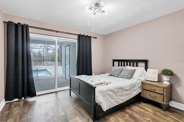 bedroom featuring a textured ceiling, access to exterior, and dark hardwood / wood-style flooring