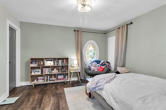 bedroom with a textured ceiling and dark hardwood / wood-style floors