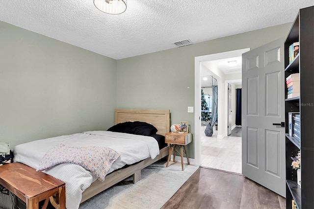 bedroom featuring a textured ceiling and wood-type flooring