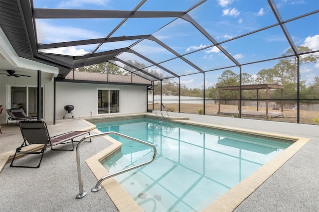 view of pool with ceiling fan, a patio, and glass enclosure