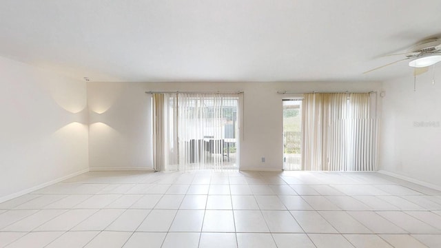 empty room with ceiling fan and light tile patterned floors