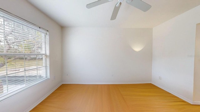 spare room with ceiling fan, a wealth of natural light, and hardwood / wood-style flooring