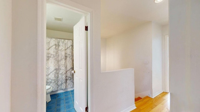 bathroom with toilet and hardwood / wood-style floors