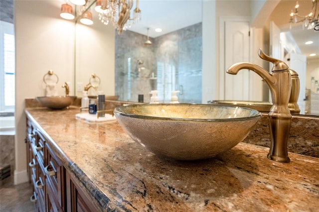bathroom with vanity, a tub to relax in, and a chandelier