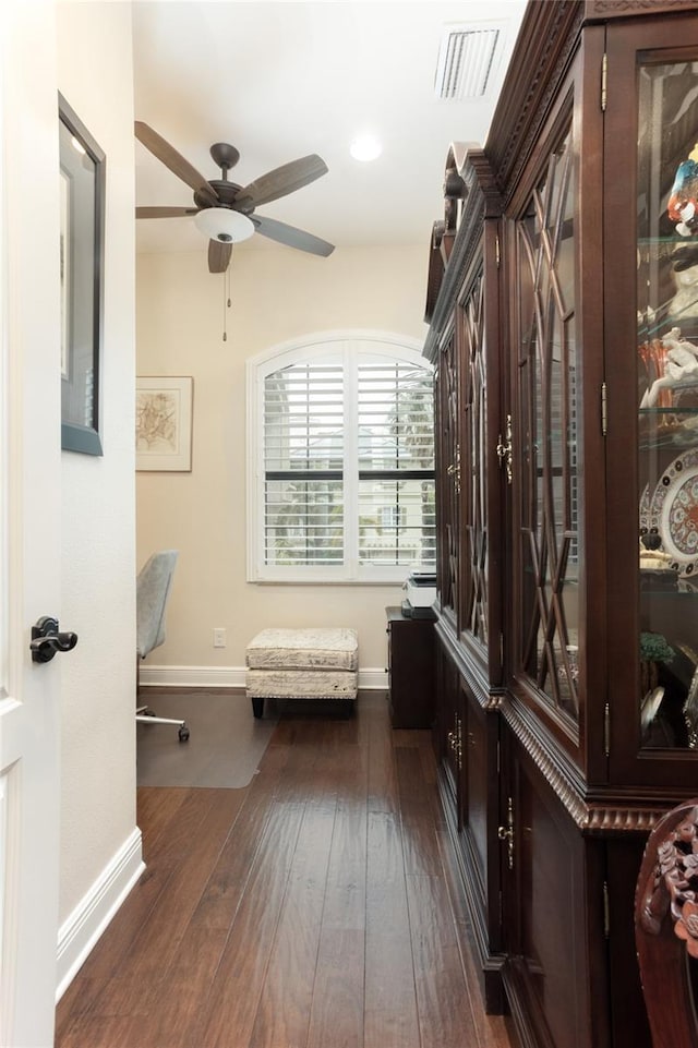interior space with ceiling fan and dark hardwood / wood-style flooring