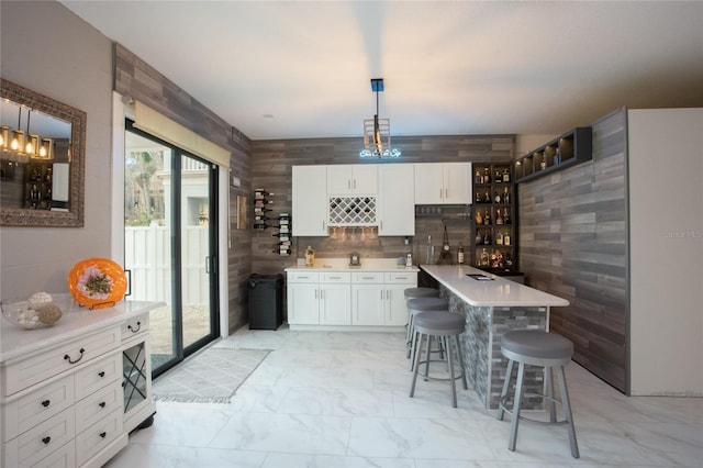 kitchen featuring pendant lighting, a kitchen breakfast bar, and white cabinets