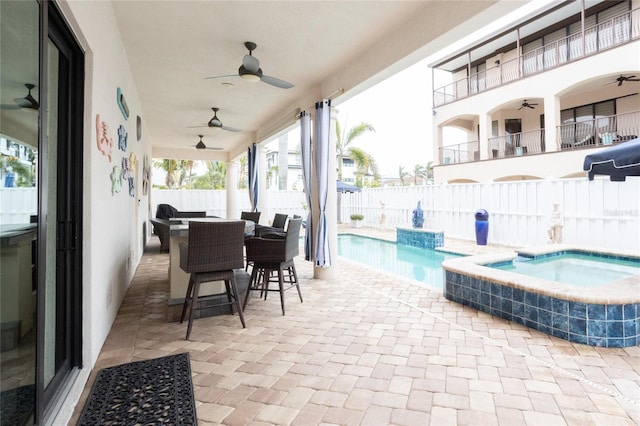 view of patio / terrace featuring ceiling fan and a swimming pool with hot tub
