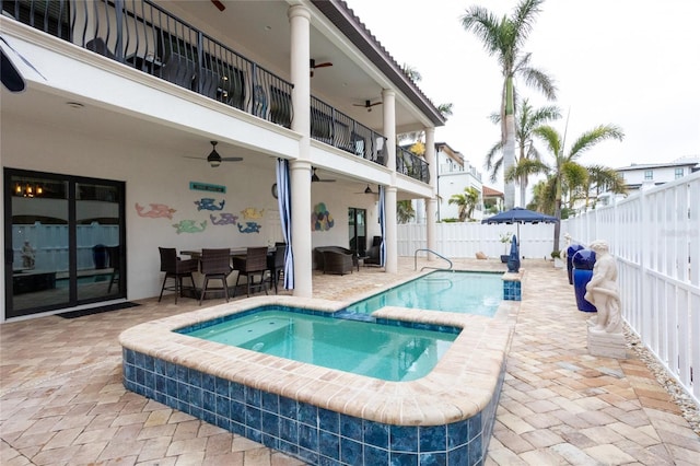 view of pool featuring an in ground hot tub, a bar, ceiling fan, and a patio area