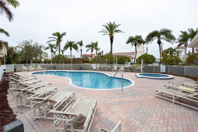 view of swimming pool with a hot tub and a patio