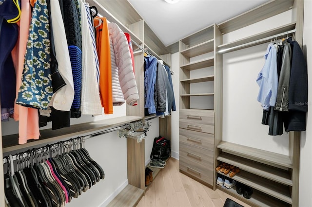 walk in closet with light hardwood / wood-style flooring