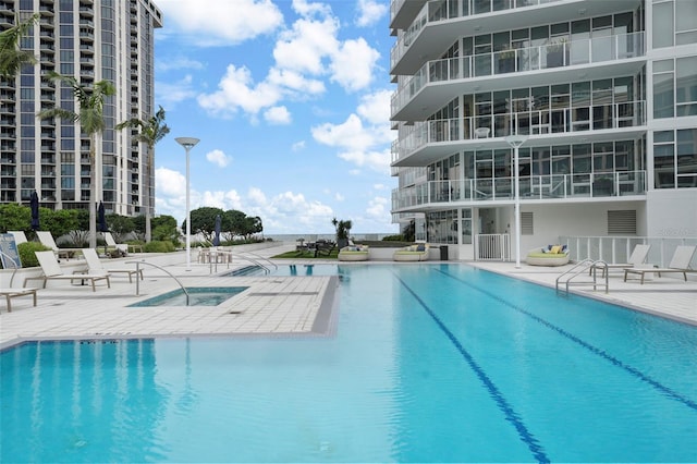 view of swimming pool with a hot tub and a patio