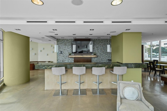 kitchen featuring decorative light fixtures, a kitchen breakfast bar, backsplash, and a center island