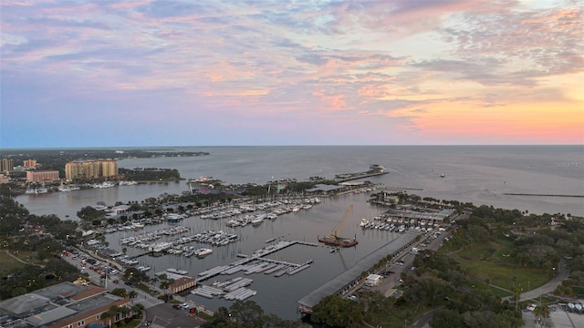 aerial view at dusk featuring a water view