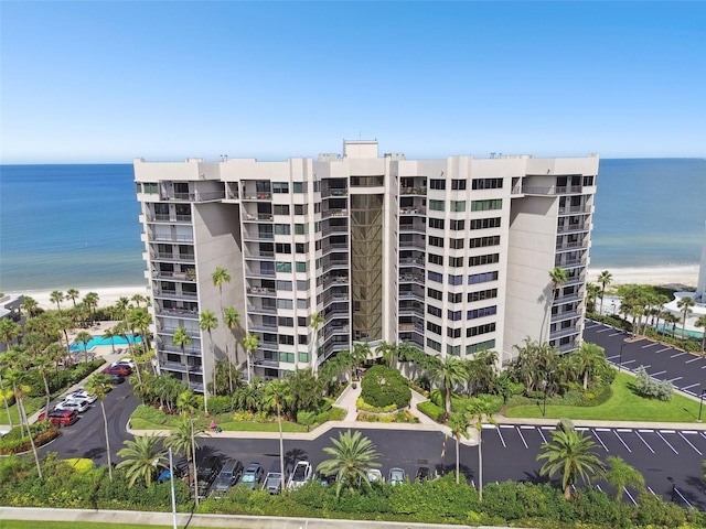 view of property with a water view and a beach view