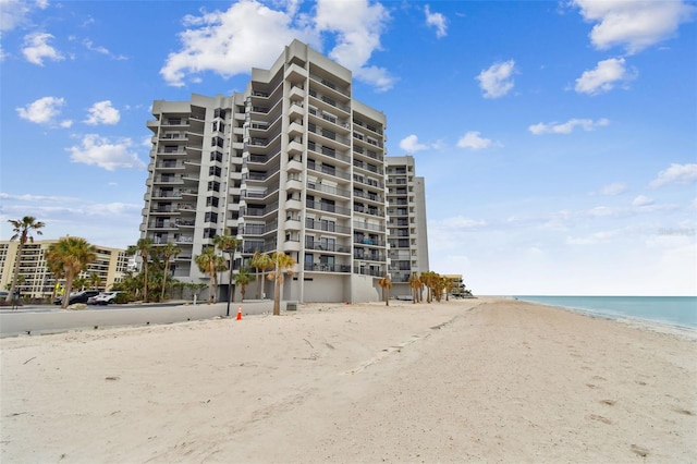 view of building exterior featuring a water view and a view of the beach