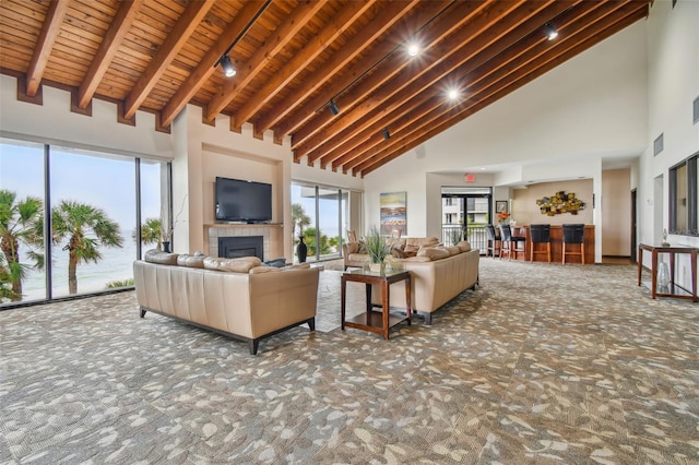 carpeted living room featuring beamed ceiling, a towering ceiling, and wooden ceiling