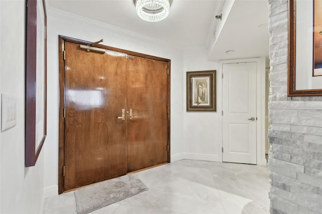 entrance foyer with baseboards and ornamental molding