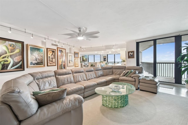 living area featuring expansive windows, carpet floors, visible vents, and a ceiling fan