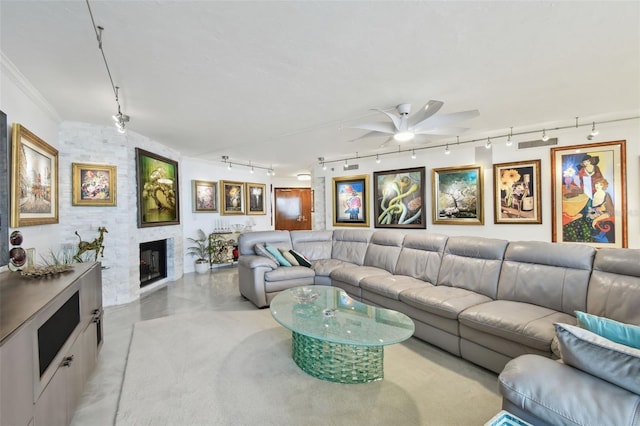 living room featuring finished concrete flooring, a fireplace, ornamental molding, and a ceiling fan