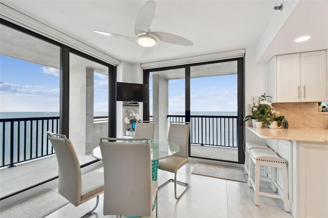 dining room featuring expansive windows and a ceiling fan