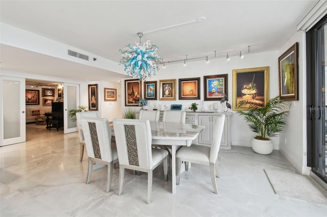 dining room featuring track lighting, baseboards, visible vents, marble finish floor, and a notable chandelier