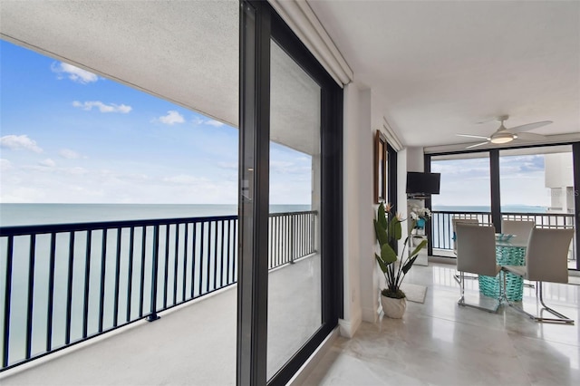 balcony featuring ceiling fan and a water view