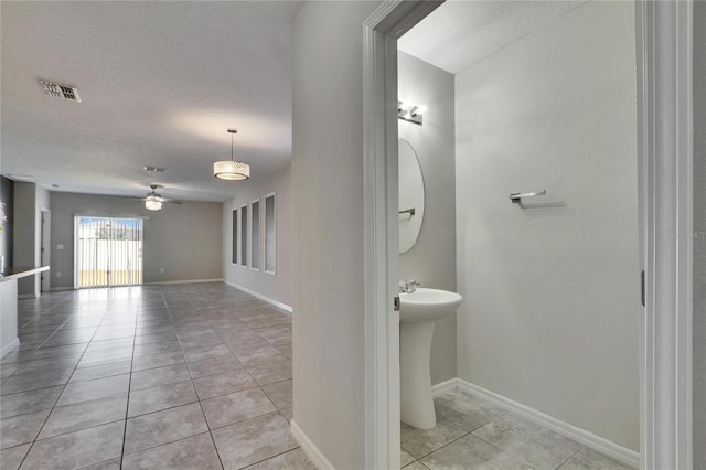 bathroom with tile patterned flooring, a textured ceiling, and ceiling fan