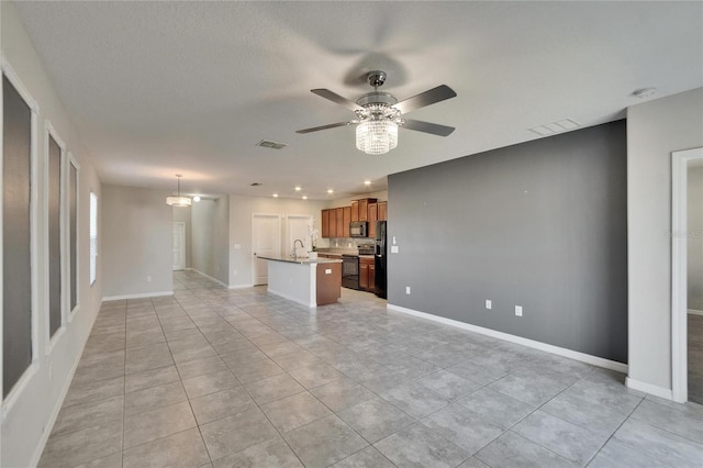 unfurnished living room featuring light tile patterned flooring, sink, and ceiling fan