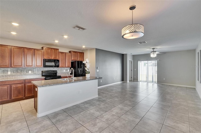 kitchen featuring light tile patterned flooring, tasteful backsplash, sink, hanging light fixtures, and black appliances