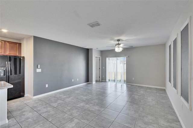 unfurnished living room featuring light tile patterned flooring, ceiling fan, and a textured ceiling