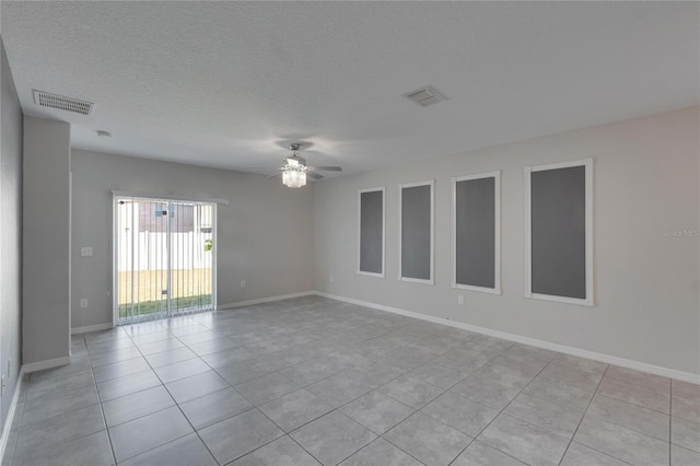 tiled spare room featuring a textured ceiling and ceiling fan