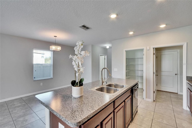 kitchen featuring an island with sink, black dishwasher, sink, and a textured ceiling