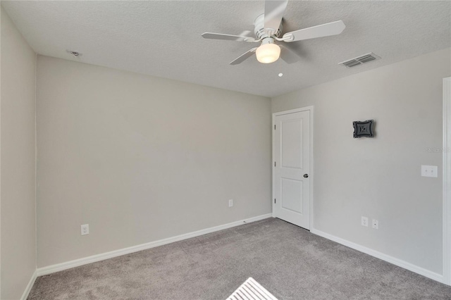 spare room with ceiling fan, light colored carpet, and a textured ceiling