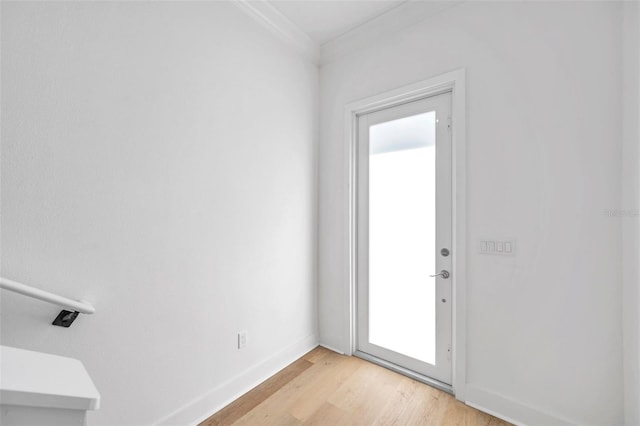 doorway featuring light wood-type flooring and ornamental molding