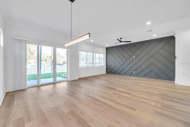 unfurnished living room featuring ceiling fan and light hardwood / wood-style flooring