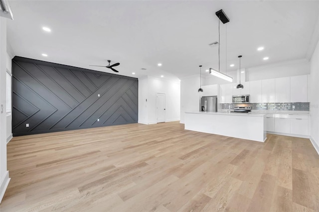 unfurnished living room featuring ceiling fan, light hardwood / wood-style flooring, and crown molding