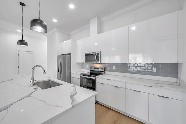 kitchen with sink, white cabinetry, hanging light fixtures, light stone countertops, and appliances with stainless steel finishes