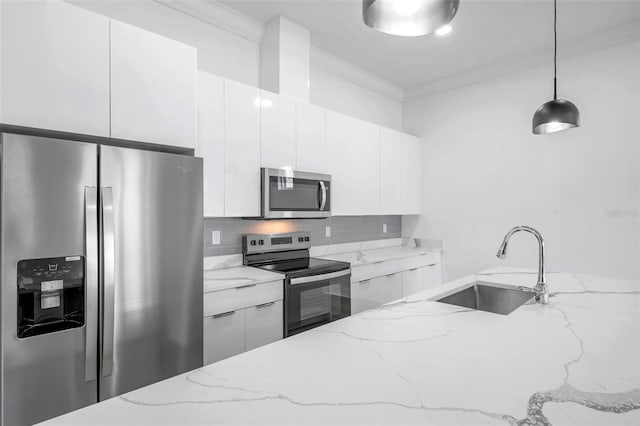 kitchen featuring stainless steel appliances, hanging light fixtures, white cabinets, light stone counters, and sink