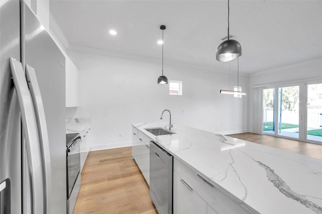 kitchen featuring decorative light fixtures, sink, white cabinetry, and stainless steel appliances