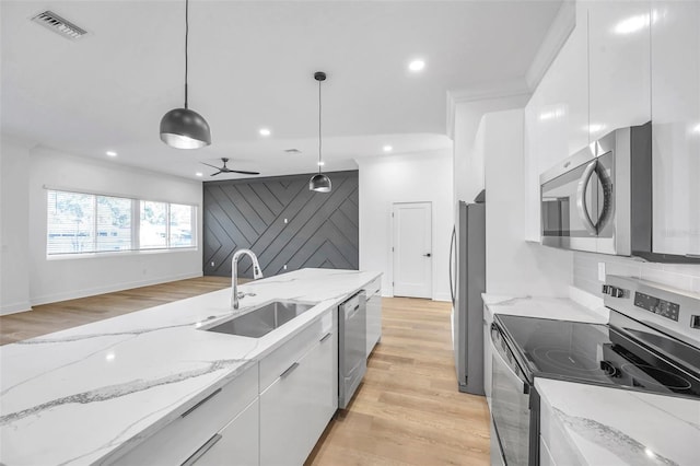 kitchen with white cabinetry, ceiling fan, stainless steel appliances, decorative light fixtures, and light stone counters