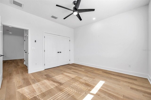 unfurnished bedroom with ceiling fan, a closet, and light hardwood / wood-style floors