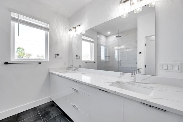 bathroom with tile patterned flooring, a shower with shower door, plenty of natural light, and vanity