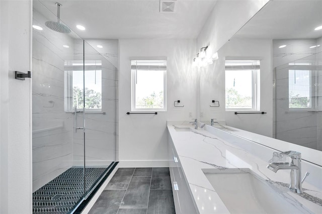 bathroom featuring an enclosed shower, vanity, and a healthy amount of sunlight